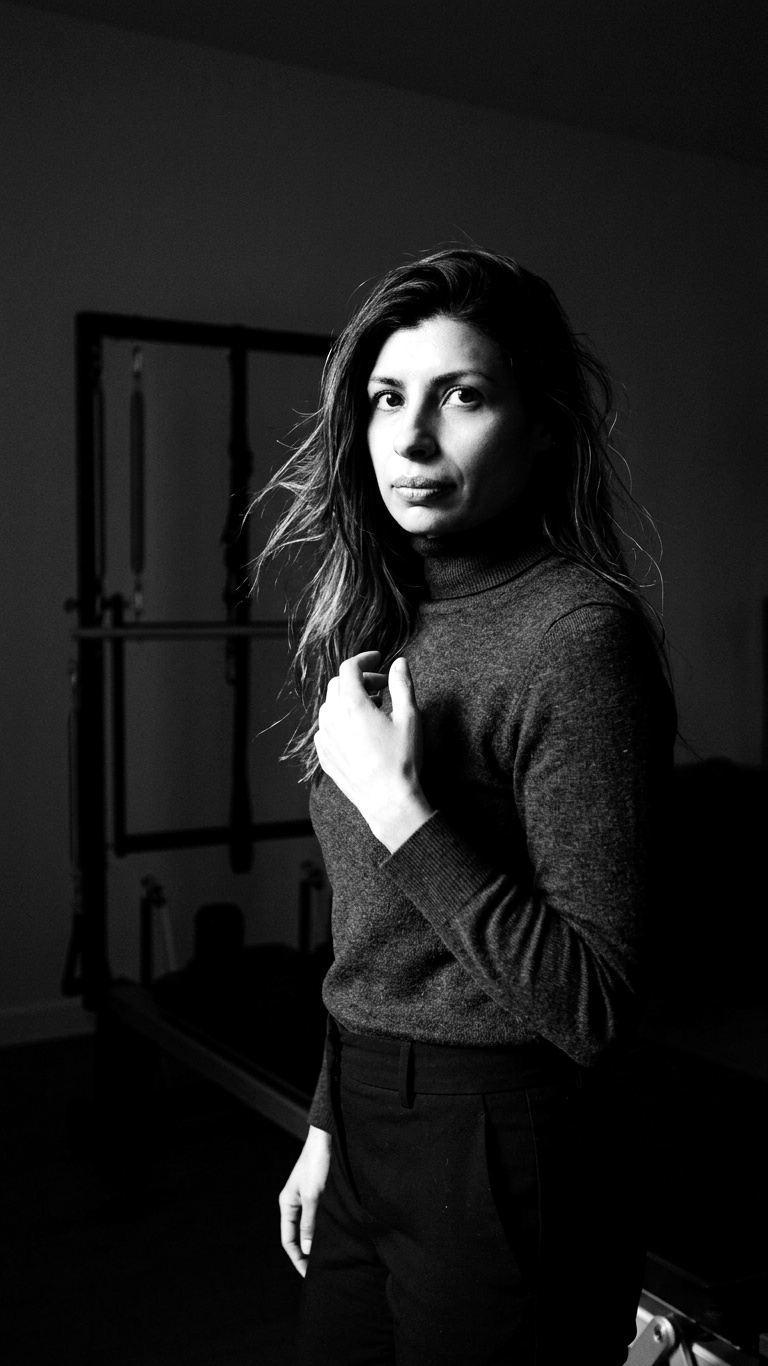 Sana Badhwar, founder of Cue Dynamics, at a distance in a dark studio